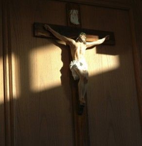 SUNLIGHT ILLUMINATES CRUCIFIX AT CEMETERY CHAPEL